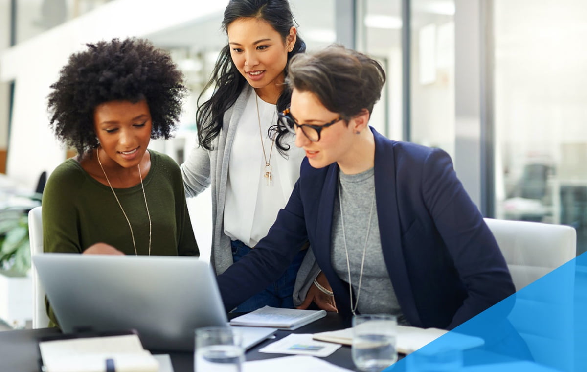 three women discussing data on a laptop